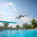 Kid Jumping off Diving Board at Riverside Pool Summer Grand Forks