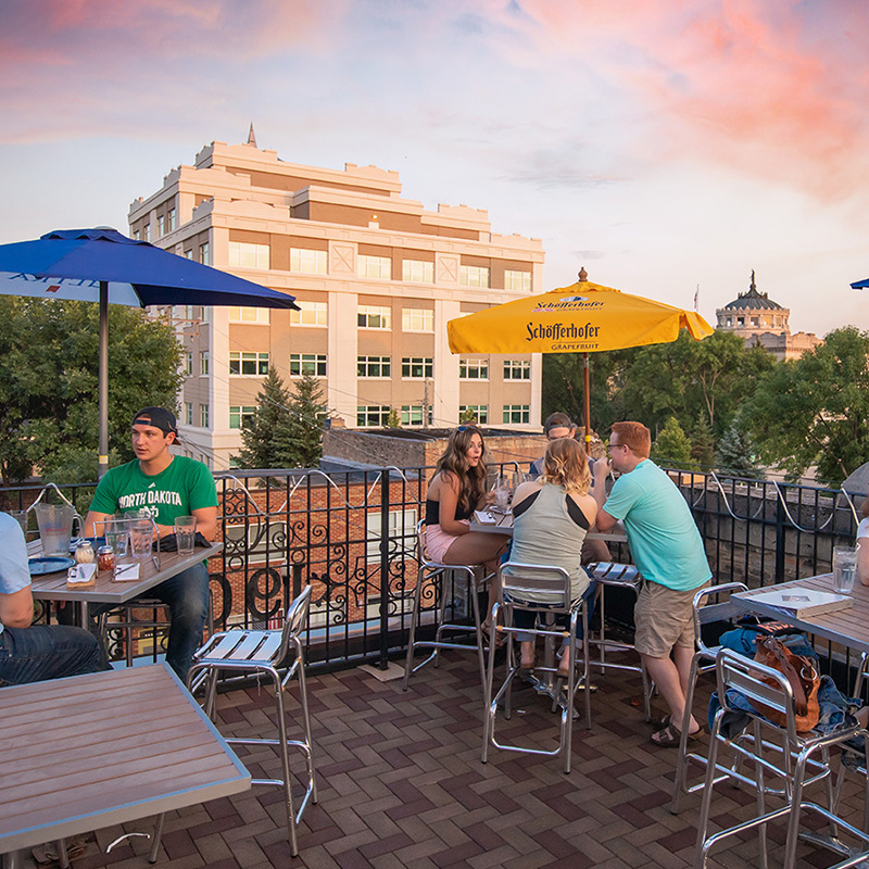People hanging out on a rooftop bar in Grand Forks.