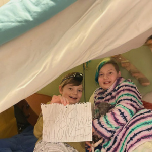 Mairi & Jonas build a blanket fort as part of their winter activities article with a sign that says "No grown-ups allowed"
