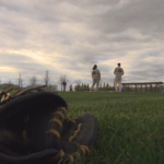 Two people standing at a softball diamond in Grand Forks