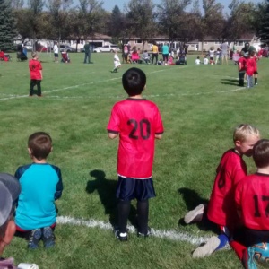 Courtney's son Ben on a soccer field with a red jersey on while playing to be fit in grand forks 