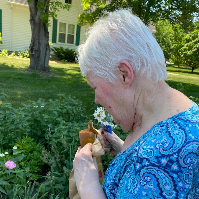 Jeanne stopping to smell the flowers in Grand Forks