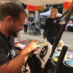 Man paints at Downtown Street Fair in Grand Forks