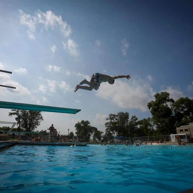 Kid jumping into the Riverside Pool in Grand Forks