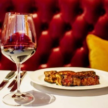 Glass of wine and plate of food in Grand Forks, North Dakota Restaurant