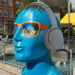 Grand Forks blue head statue with headphones on.