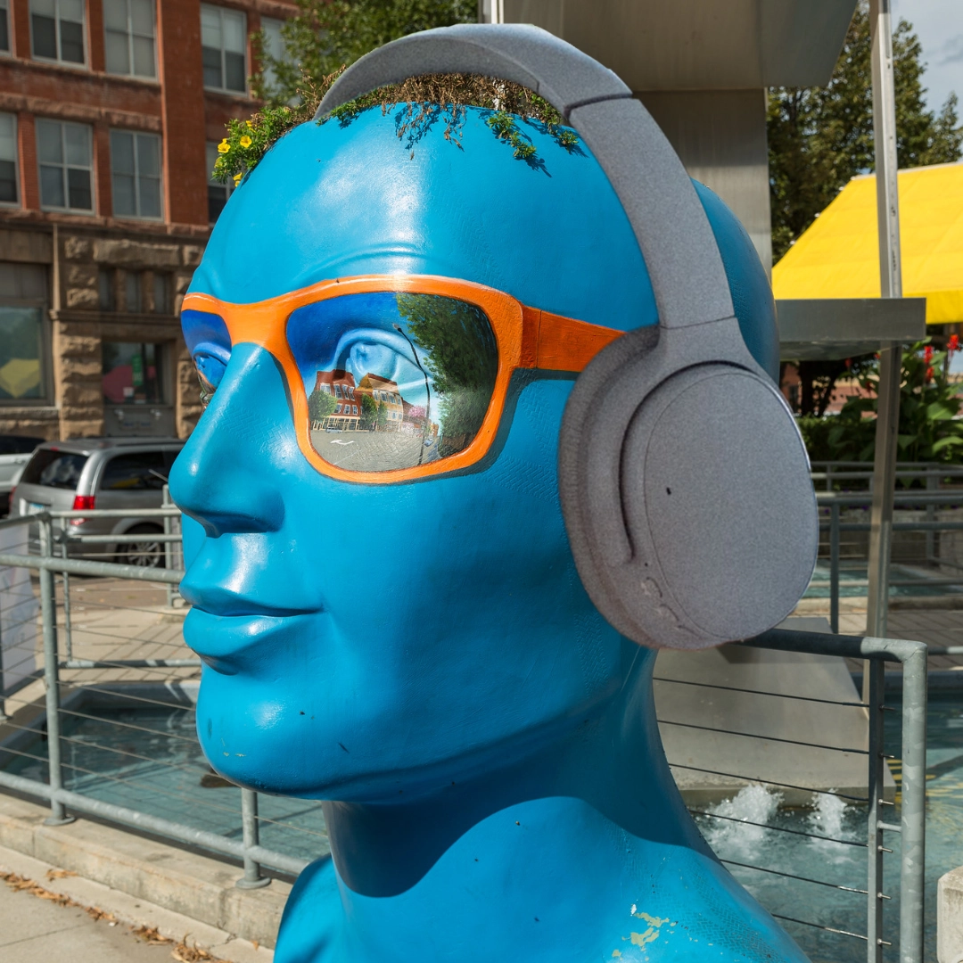 Grand Forks blue head statue with headphones on.