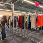 Girl looking at clothes in Salvation Army thrift store in Grand Forks, ND