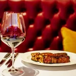 Glass of wine and plate of food in Grand Forks, North Dakota Restaurant