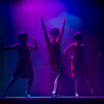 3 Women standing on the stage at the Empire Theater in Grand Forks.