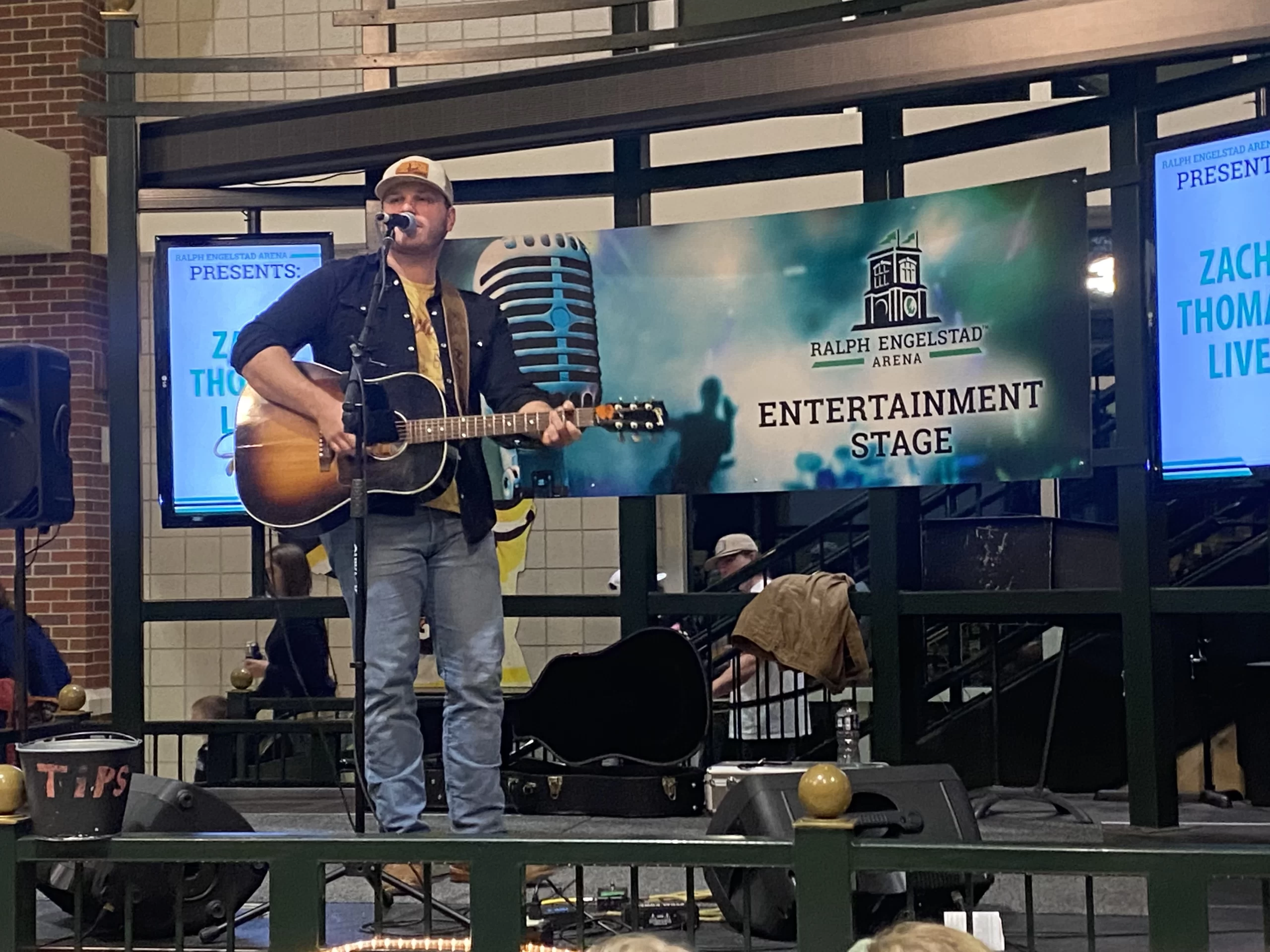 Man sings on stage at Ralph Engelstad arena in Grand Forks at UND Hockey game.