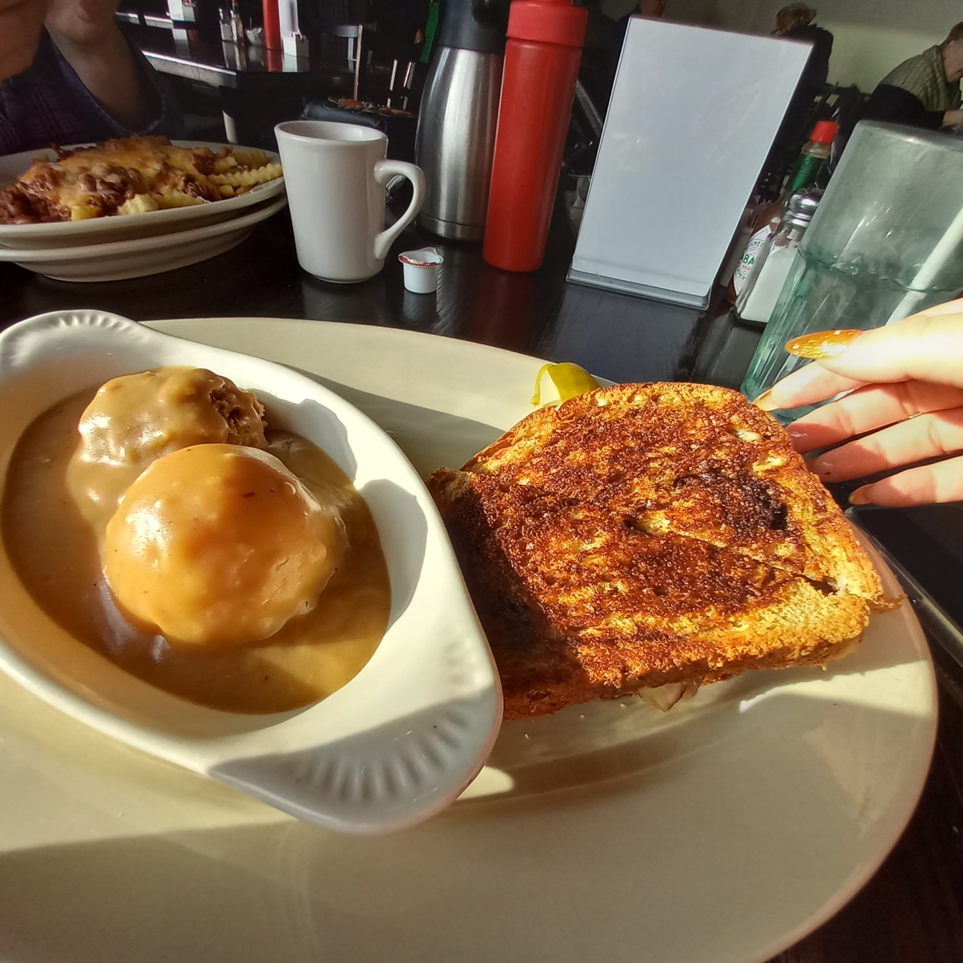 Patty melt sandwich in front of plate of mashed potatoes and gravy in café in Grand Forks, ND.