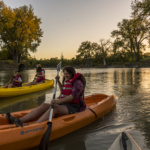 Two women kayak on the Red River in Grand Forks, ND