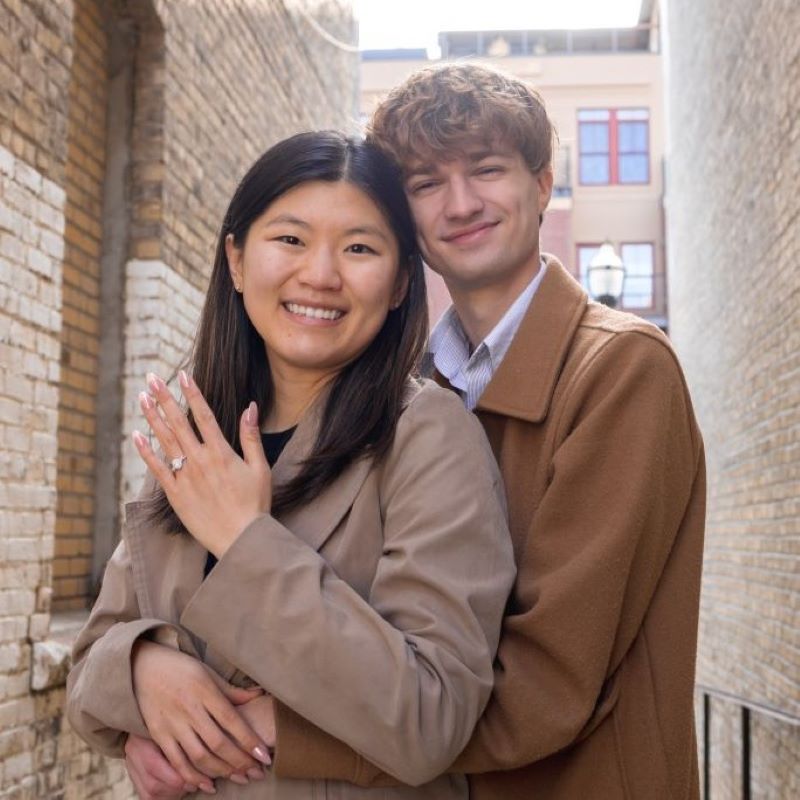 What's Cooler Today writer Molly showing off her engagement ring with her fiancé in a brick alleyway