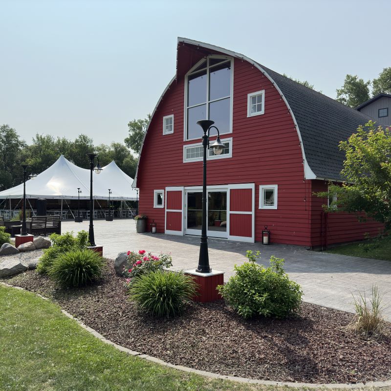 Naastad Acres- A well-kept two story red barn surrounded by landscaping and light poles