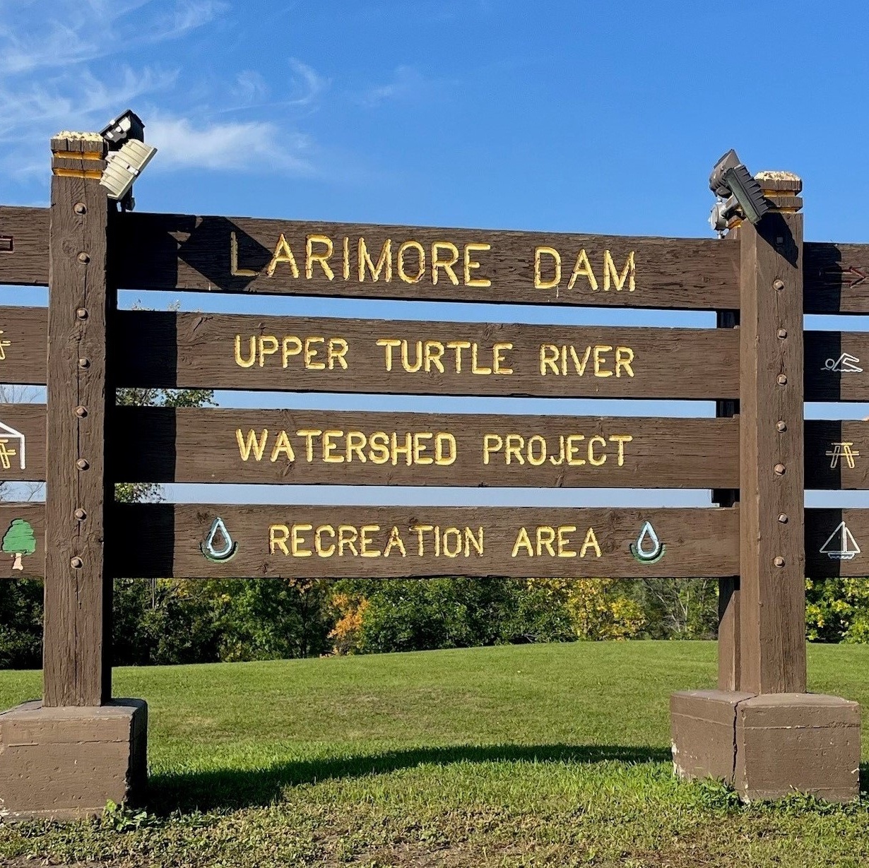 A wooden sign that reads "Larimore Dam Upper Turtle River Watershed Project Recreation Area"