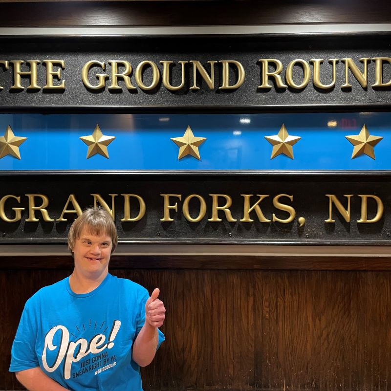 Author Erin in front of the Grand Forks Ground Round sign.