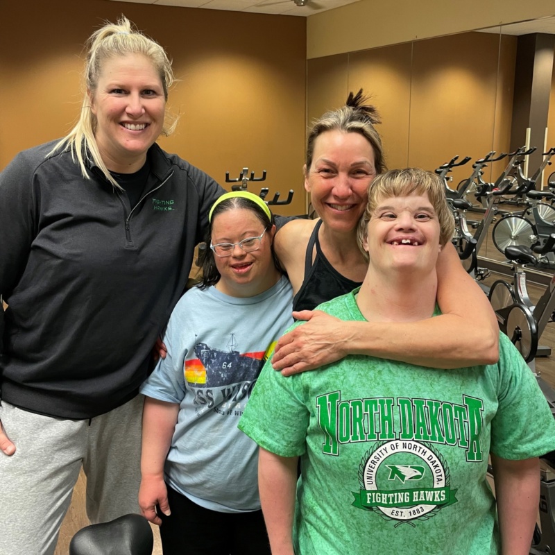 Author Erin stands smiling with friends after EPIC spin class in Grand Forks.