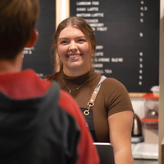 Woman smiling at a customer at the Ember Coffeehouse in Grand Forks.