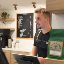 Man stands at the register at the Ember Coffeehouse in Grand Forks.