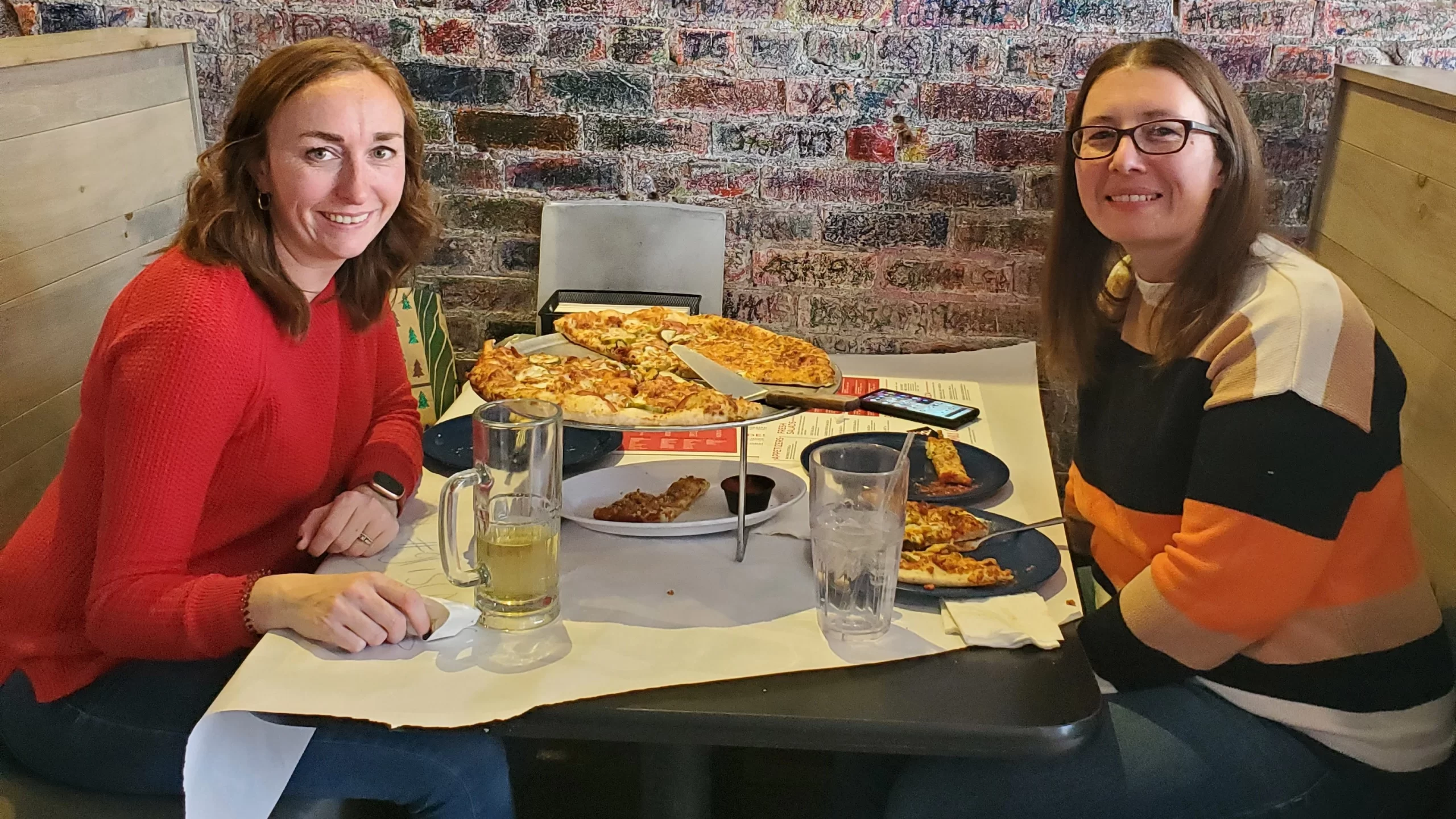 Kayla and friend eating pizza at Rhombus Guys in Grand Forks.