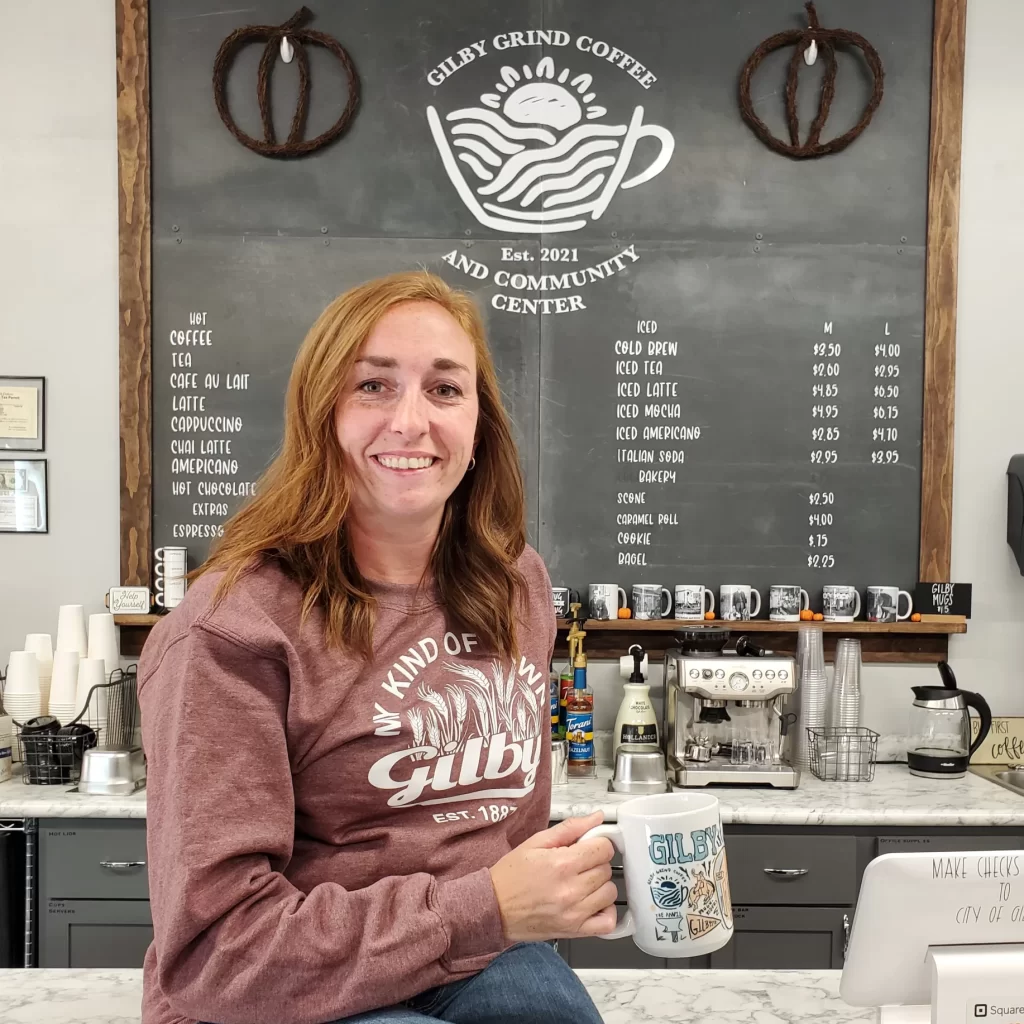 What's Cooler Today? Article author Kayla sits with a cup of coffee in a Gilby Coffee Shop