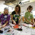 Three girls participating in an art class.