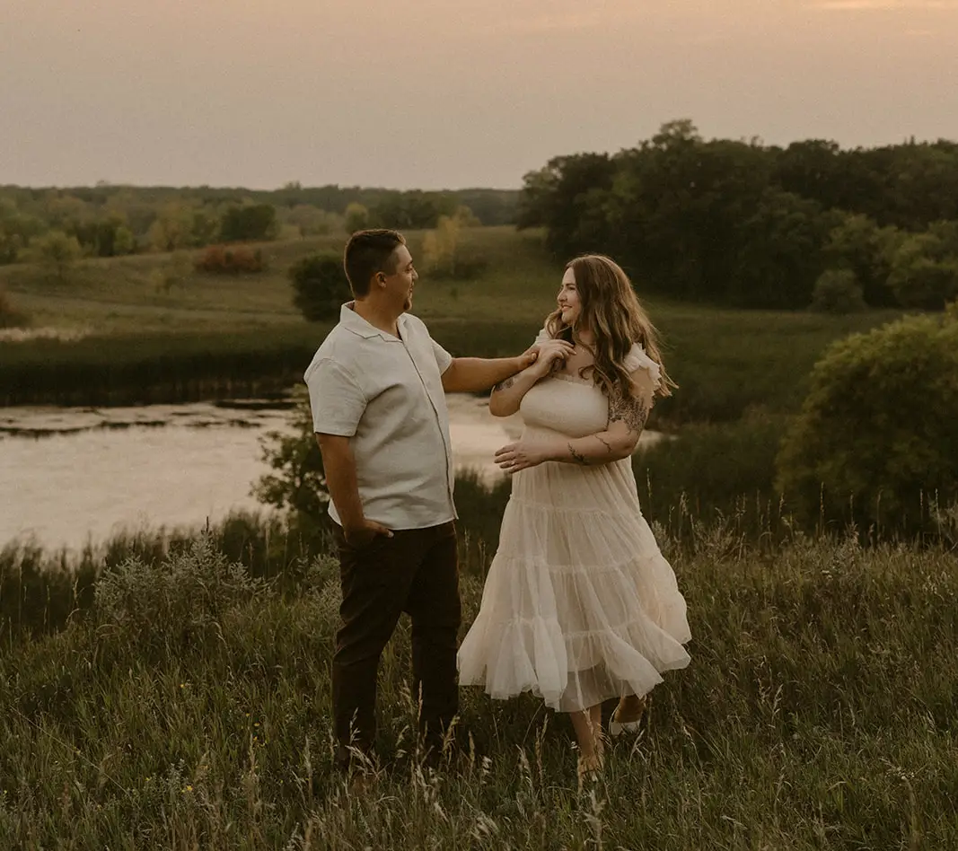 Couple in a field in the Grand Forks County Region at sunset