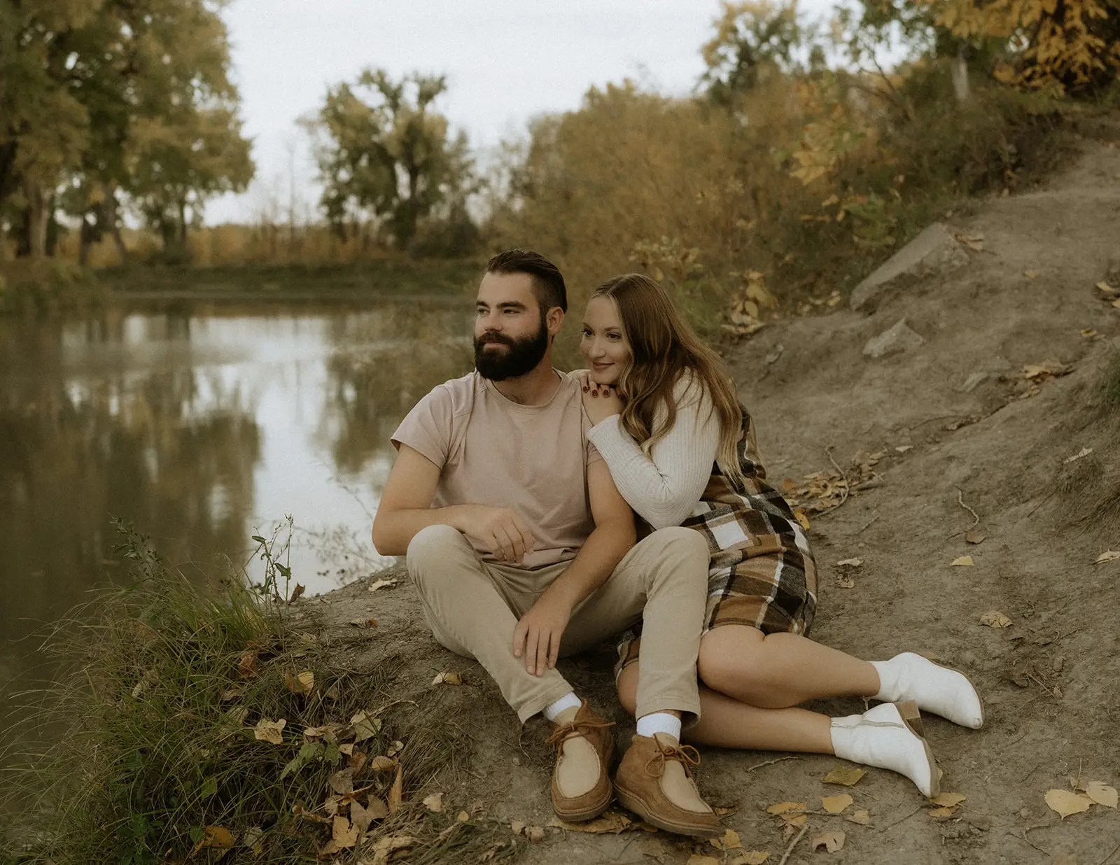 Couple sitting by the river in Grand Forks Region