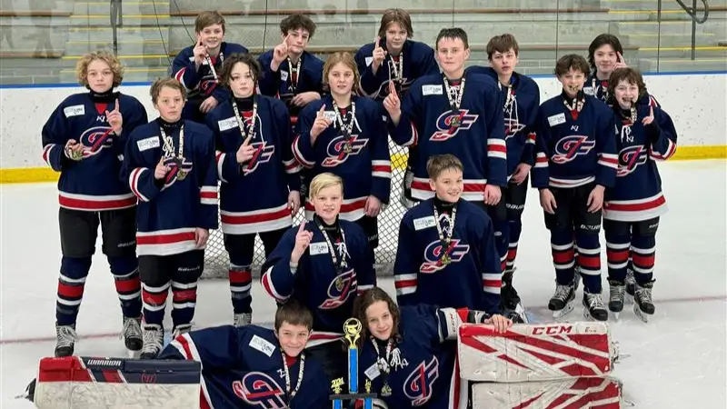 Grand Forks Boys Hockey team poses for victory picture on the Ice Rink