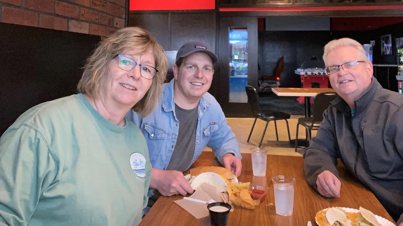3 people sit at Grand Forks Red Pepper with Food smiling at the camera