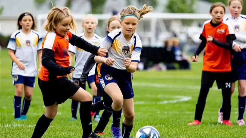 Girls fighting over the soccer ball on the field in Grand Forks.