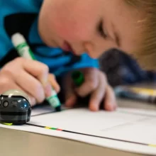 Kid drawing with green marker at Grand Forks Public School