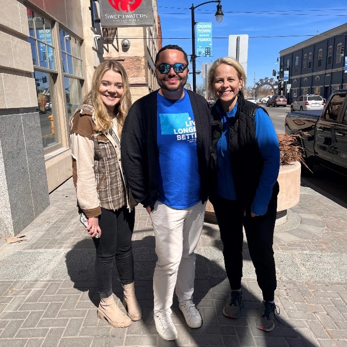 WCT writer Kenneth stands with two female Blue Zones employees while wearing a Grand Forks Blue zones shirt