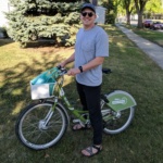 WCT writer Paul stands and smiles at the camera while on an Altru Bike Share bike.