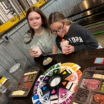 Whats cooler Today writer Brae sits at a table at Half Brothers with a friend as they play Trivial Pursuit and enjoy some snacks.