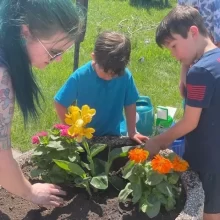 Kids planting flowers for volunteering in Grand Forks.