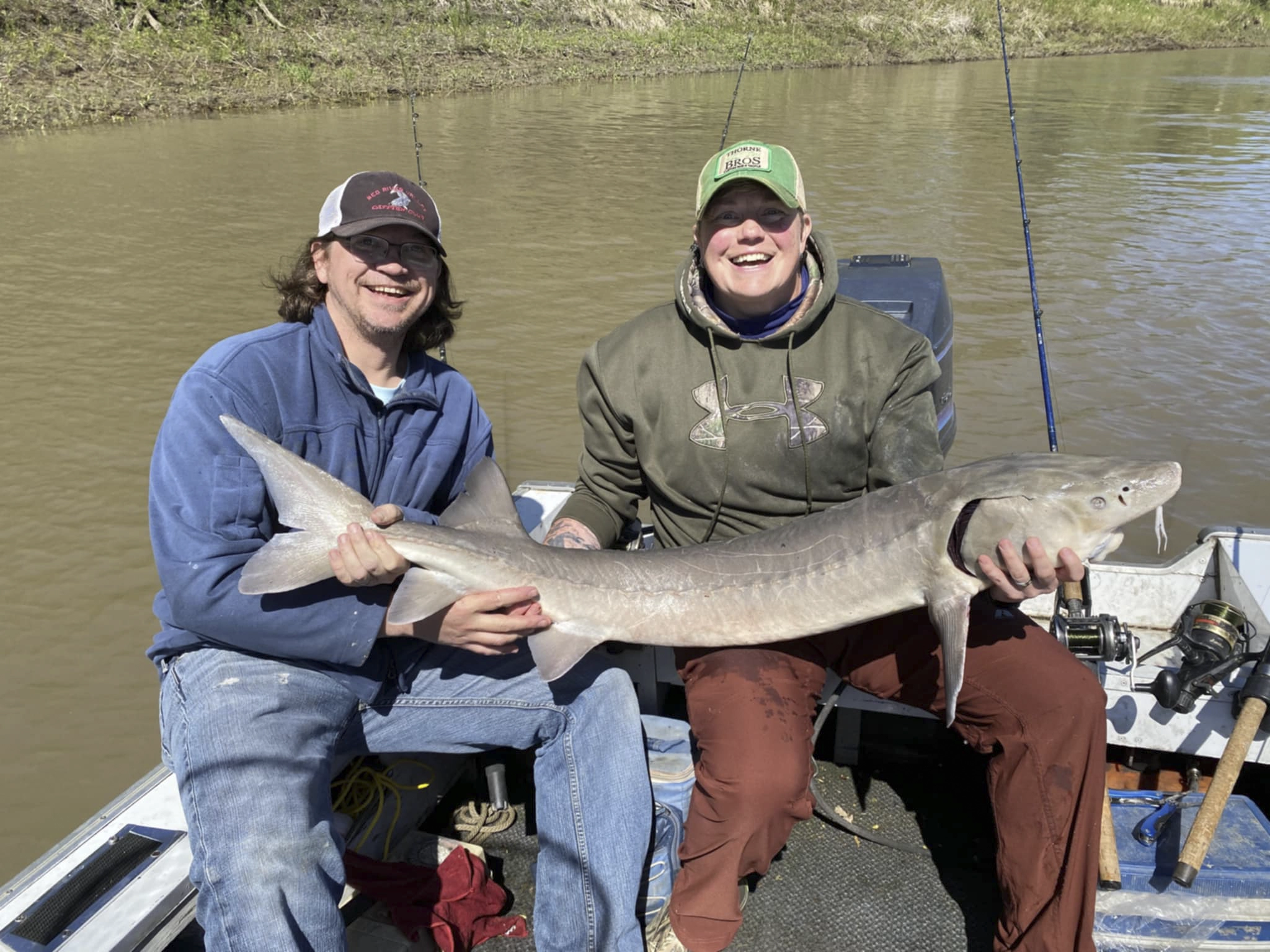 Wade Anderson and Andrea Charliebois holding a 56-inch Lake Sturgeon, May 2024.