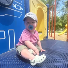 Baby at a Grand Forks park wearing a pink top.