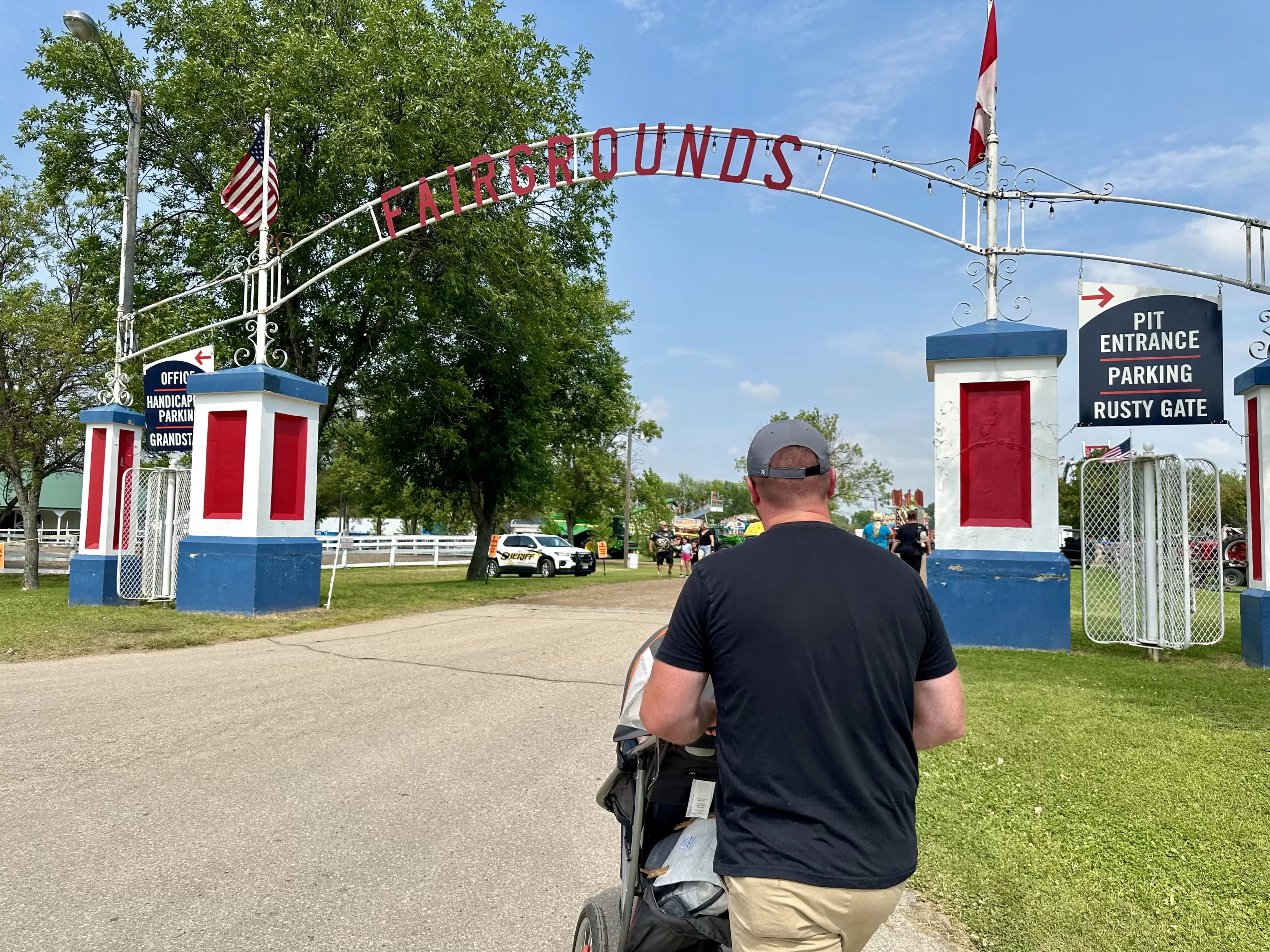 Dad pushing a stroller into the Fairgrounds near Grand Forks.