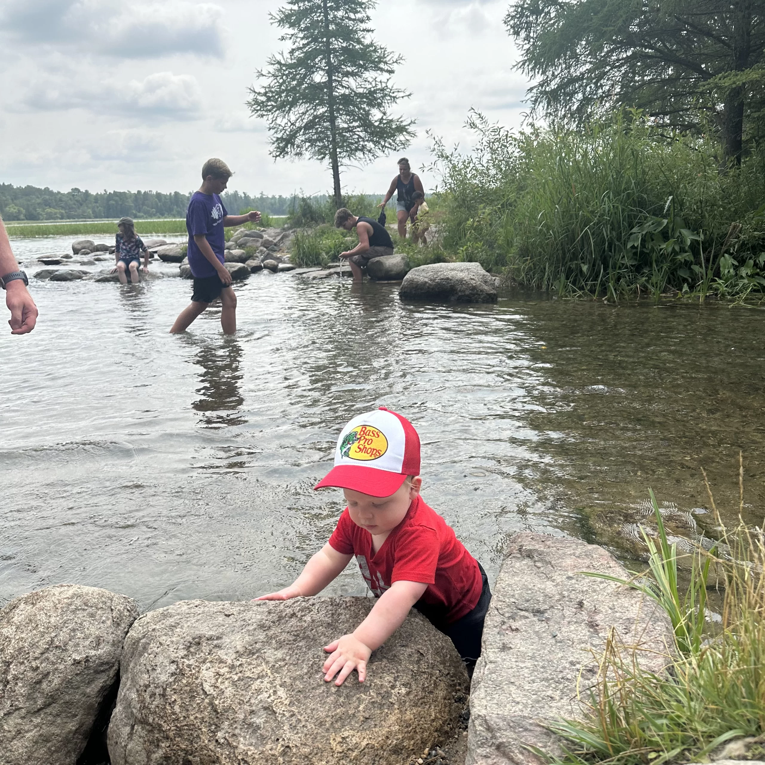 Baby playing with rocks in the river near Grand Forks.