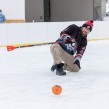 A man makes a dramatic slide on the ice as he plays broomball in downtown Grand Forks