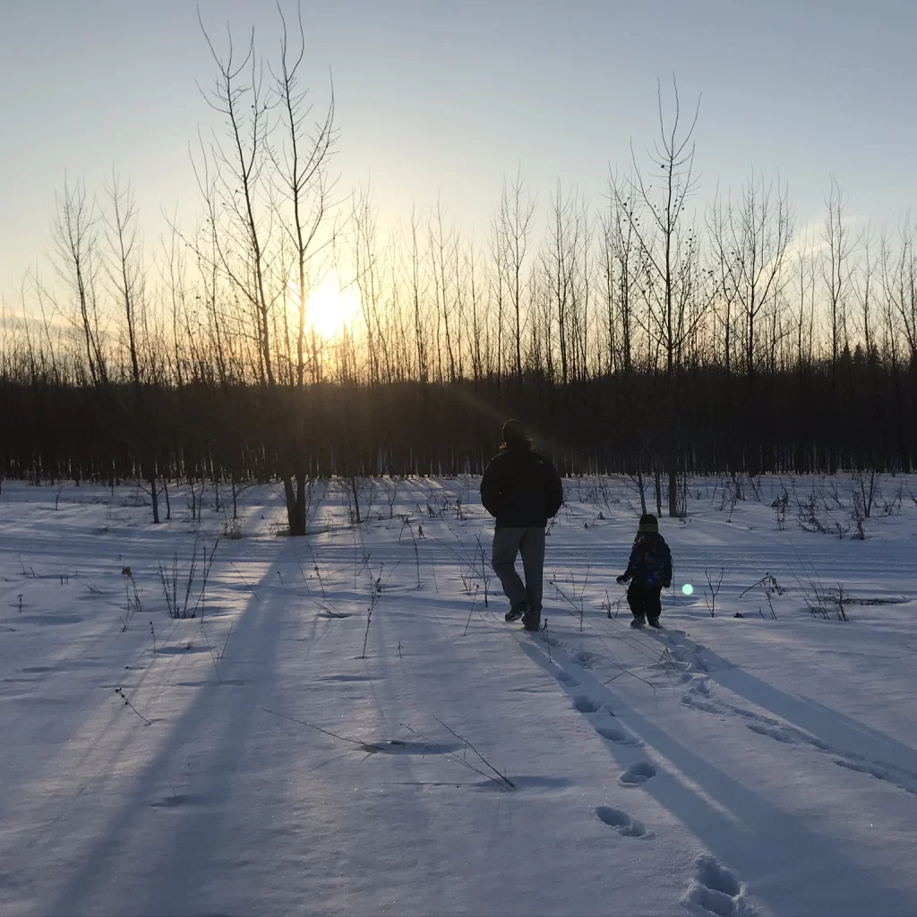 Wade and Jude Anderson walking toward the river on a snowy day