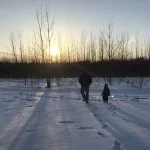 Wade and Jude Anderson walking toward the river on a snowy day