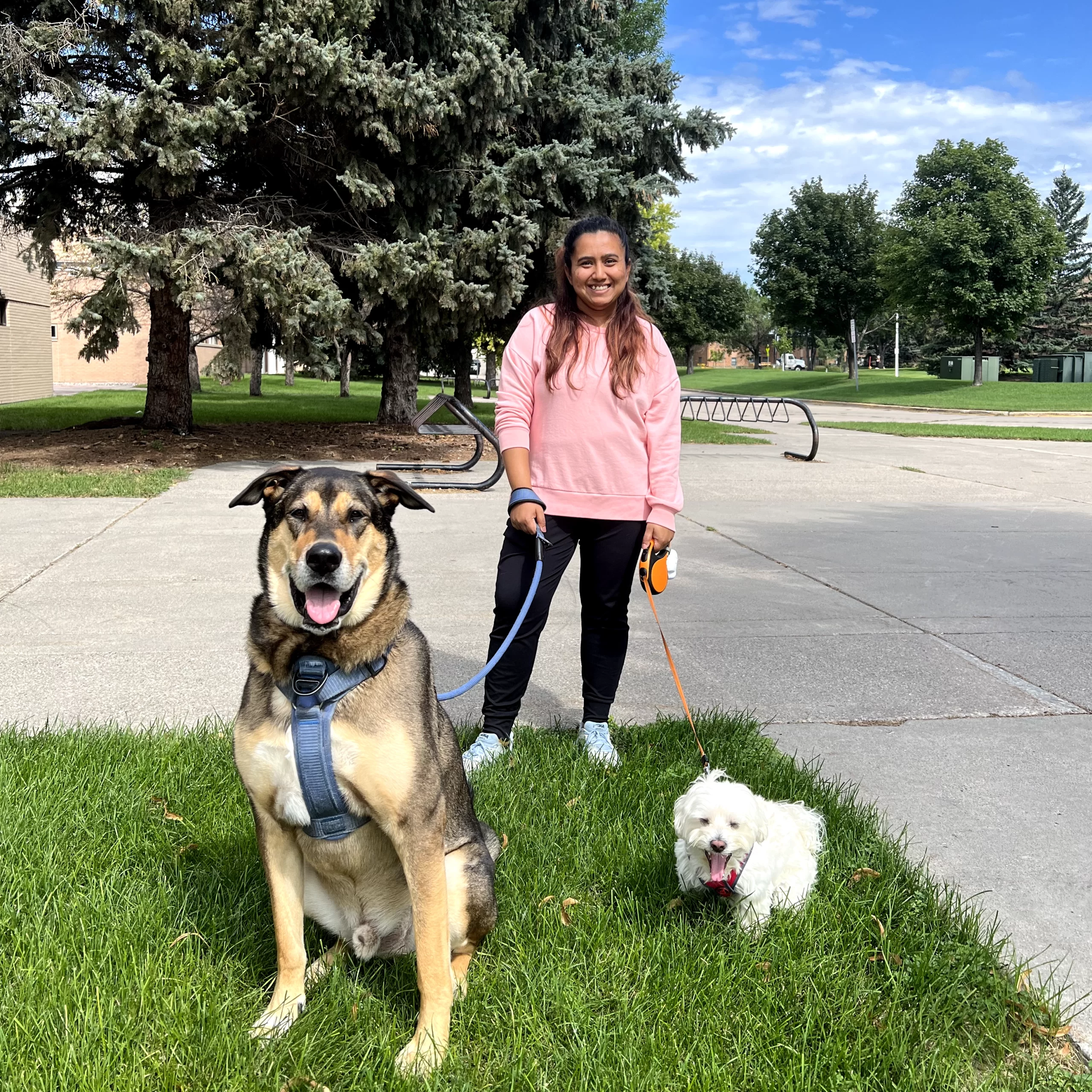 Benu stands with two dogs, one the very small Rio, and the other a very massive Meso.