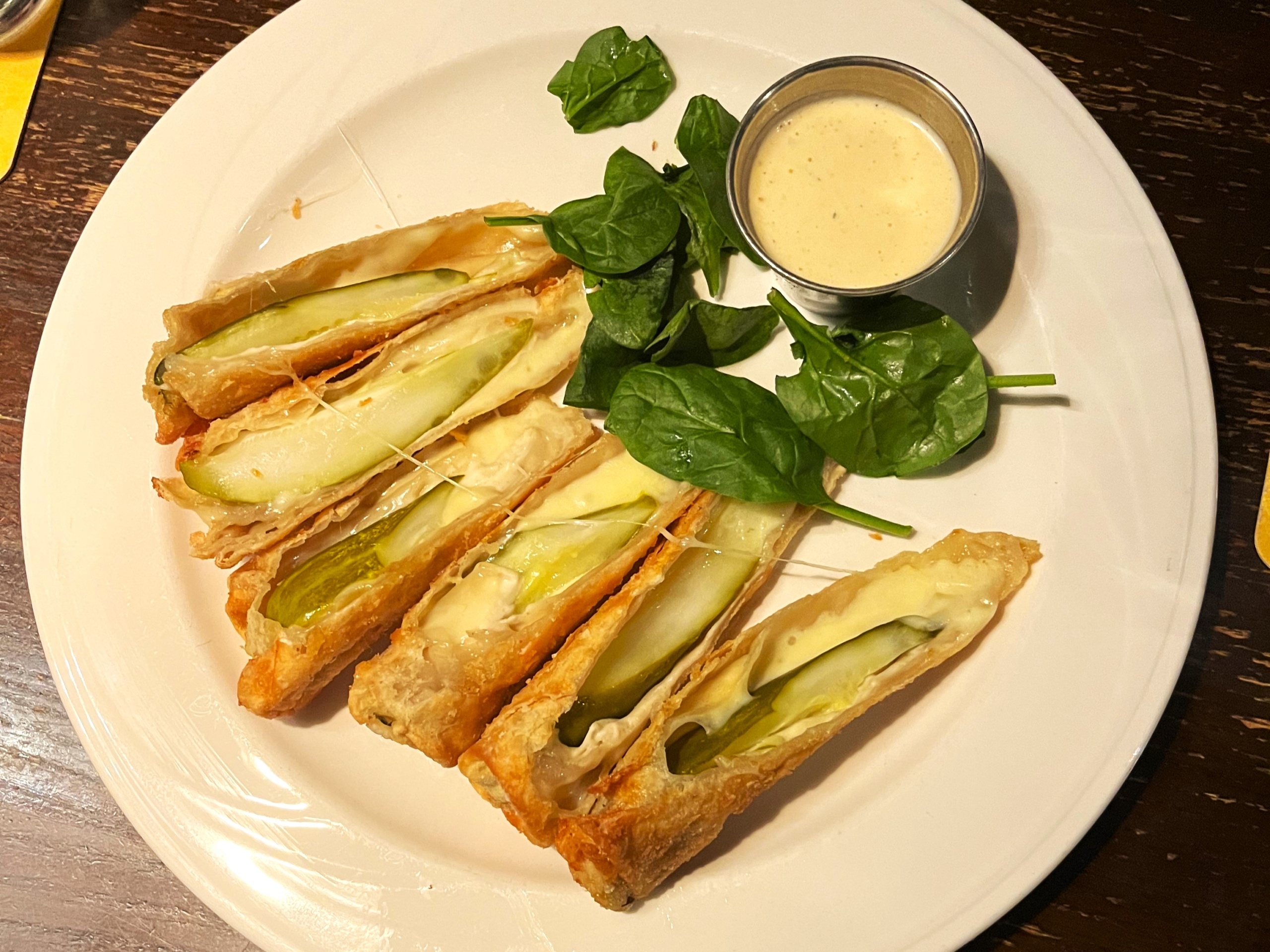 A plate of fried pickles from Toasted Frog, garnished with spinach leaves.