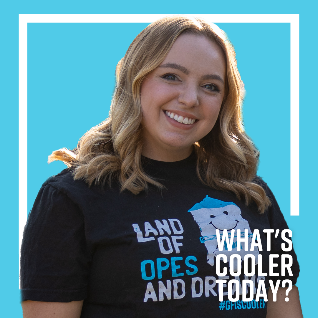 What's Cooler Today author Brenna smiles in her Cooler merch on front of a blue graphic that reads "What's Cooler Today"