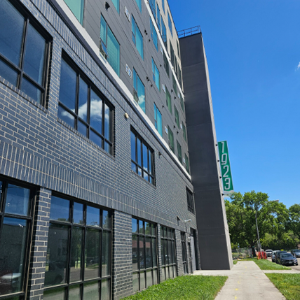 Exterior of 1923 at the beacon apartments. Gray brick with big tall windows.