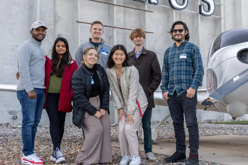 Group photo of seven ggfyp members in front of Cirrus after taking a tour of the business.