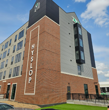 Hyslop Memorial Apartments outdoor exterior photo. Red brick and grey siding with some black accents.